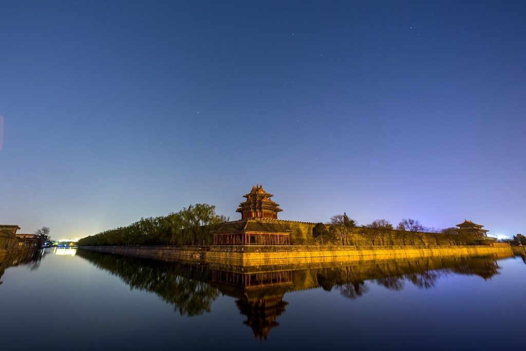 Northeast corner tower of the Forbidden City reflected in the moat at night
