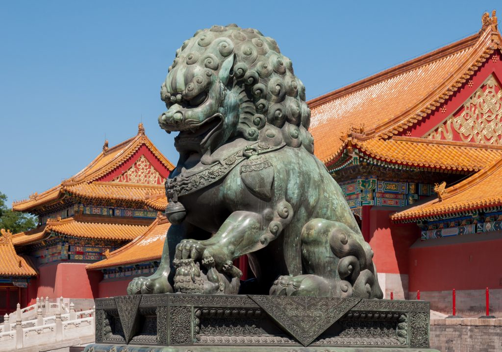 Visitors walking across stone paving inside the Forbidden City