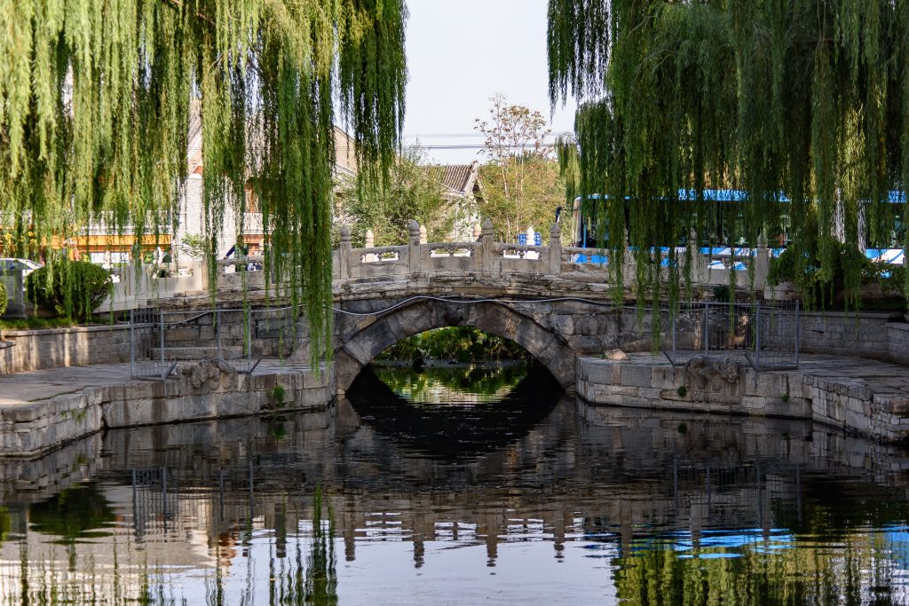 Stone arch of Wanning Bridge and willow trees in Beijing